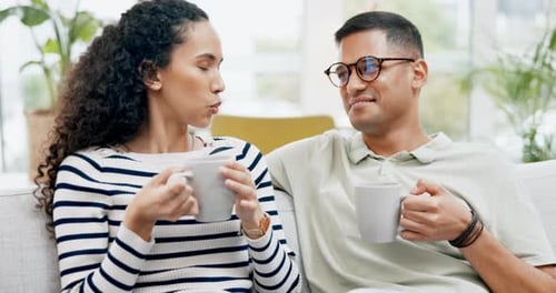 Young Couple Chatting on Sofa with Coffee
