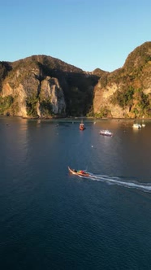 Aerial video over a traditional boat on the famous Koh Phi Phi island at sunset, Thailand