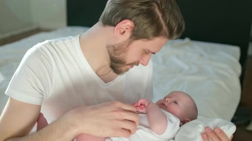 Loving Father Gently Holding Infant Baby Indoors