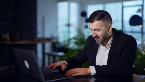 Successful young businessman working with computer in office. Handsome office manager working