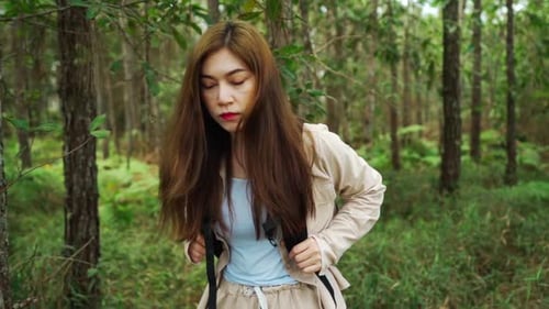 slow-motion of young woman carrying a backpack travel and walking in the forest