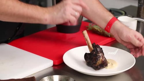 Chef Plates Braised Meat Dish in Kitchen