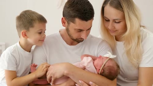 Loving Family Poses with Newborn Baby Indoors