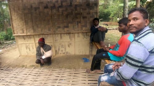 Meeting men resting in bamboo shed at Assam village. Assam, India