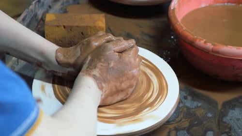 Closeup of Children's Hands Sculpting Ceramic Dishes From Clay in the Workshop