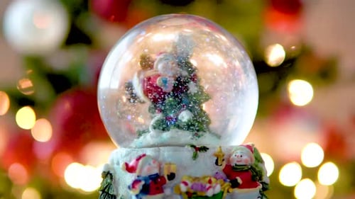 Christmas Snowman Globe with Snow flakes, Lights Blinking on Christamas Tree in Background