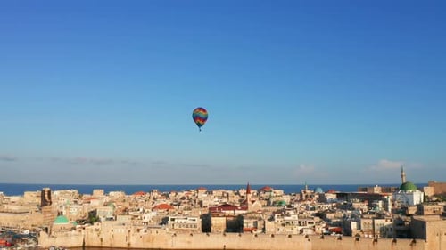 Hot air balloon passing over Acre old city port houses and Mosque at sunrise, Aerial view