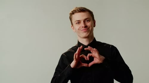 Young Man Gestures a Heart with His Hands