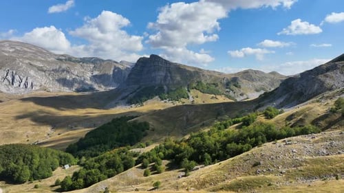 Flight over beautiful mountain peaks covered with grass. Mountain from above on a sunny autumn day.