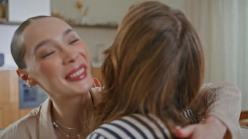 Two Women Embrace in a Bright and Airy Home