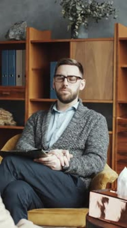 Man listens to woman in therapy session indoors