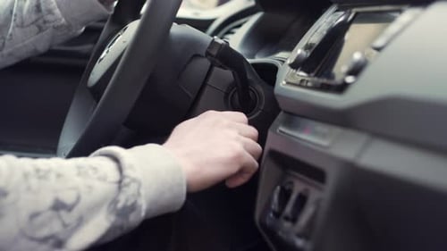 Starting car with keys in hand, side closeup view from inside