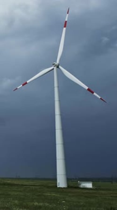 Windmill or wind turbine on wind farm in rotation