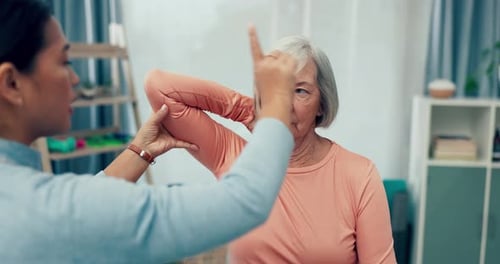 Senior Woman Doing Stretches at Home With Assistance