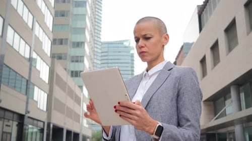Woman Working on Tablet in City