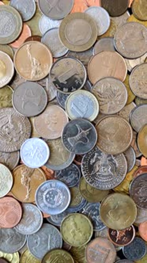 A background of silver, gold, and copper coins of various denominations. Metal coins