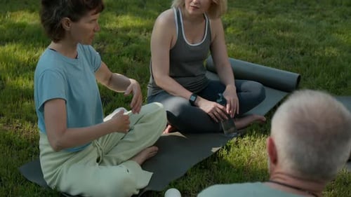 Qigong Trainer Talking to Seniors after Outdoor Practice in Park