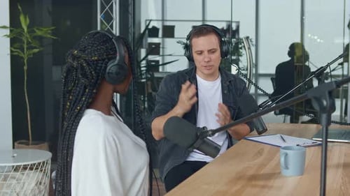 Un présentateur masculin communique avec un invité, un Afro-Américain