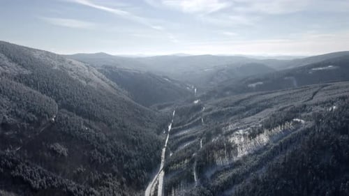 Luftaufnahme der malerischen alpinen Berglandschaft im Winter, des unberührten Tals und der schneebedeckten Bäume