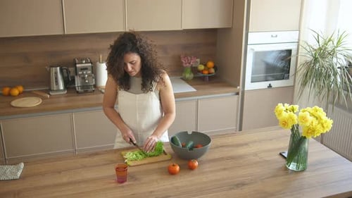 Woman Preparing Fresh Salad in Bright Kitchen