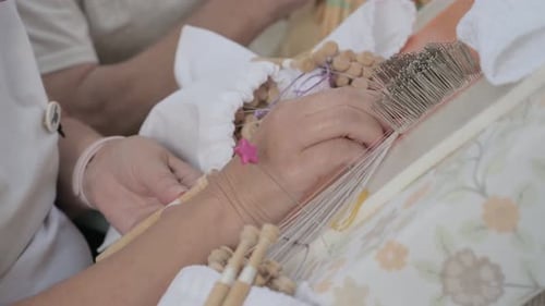 Artisan women's hands knitting bobbin lace