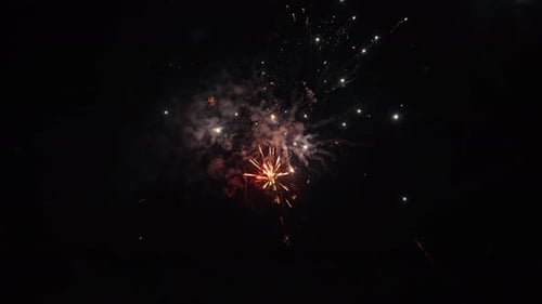 Colorful fireworks explode in the night sky during a festive celebration, creating a vibrant and