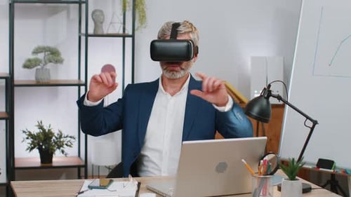 Mature Business Man in VR Goggles Watch Virtual Reality Video Working on Simulation Game at Office