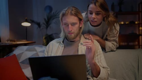 Man and Woman Using Computer for Online Reservation at Home