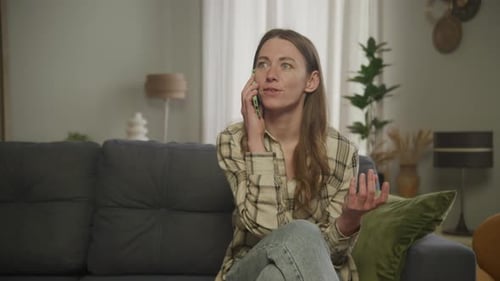 Joyful Woman Speaking on Phone Call Using Smartphone Intdoors