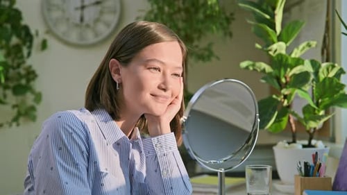 Young Attractive Woman with Natural Makeup Looking in Mirror