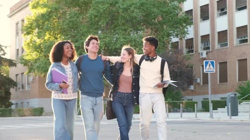 Diverse group of happy university students walking on campus