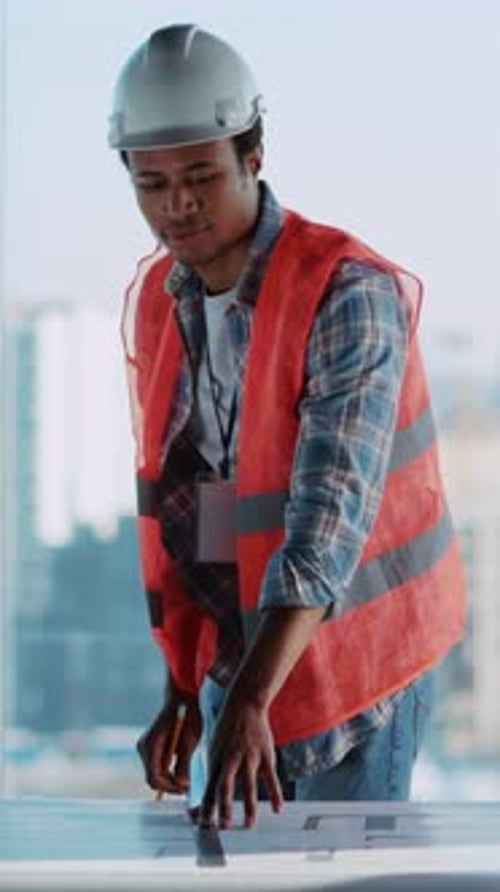 African Young Civil Engineer Working on Construction Plan Blueprint Map Paper in Corporate Office
