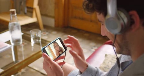 4K-Videoaufnahmen eines jungen Mannes, der sein Smartphone benutzt, um einen Videoanruf zu tätigen