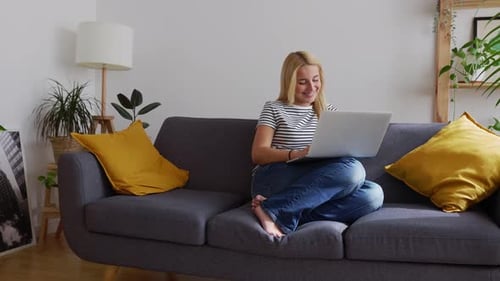 Woman Using Laptop Computer on Gray Sofa