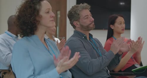 Adults Clapping in Conference Audience