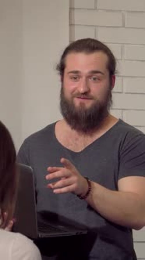 Dynamic Young Bearded Businessman Engaging Colleagues During an Office Meeting