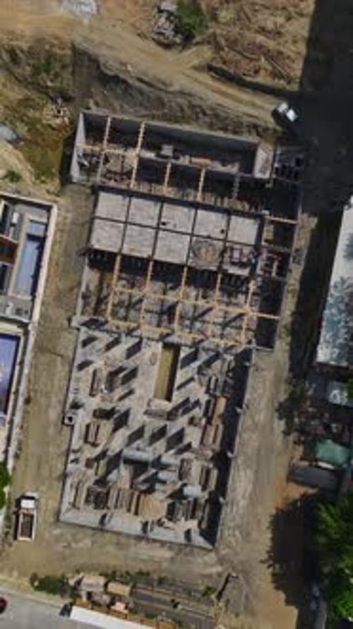 Los ingenieros de vídeo vertical supervisan a los trabajadores que construyen paredes para un nuevo nivel en un sitio muy transitado