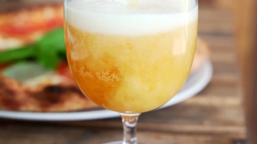Man is pouring beer in a pizzeria, close up on the foam, and bubbles.