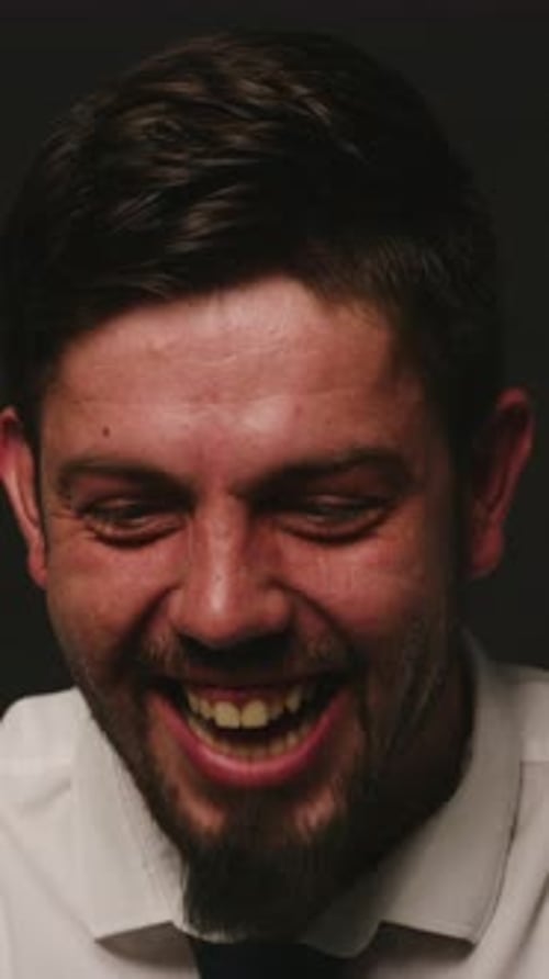 Schizophrenia, psychology and face of man in studio with emotions, mood swings and laughing