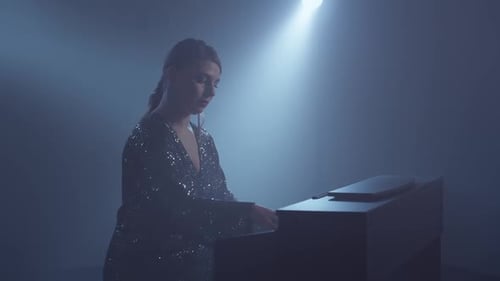 Elegant Woman Playing Piano in Smokey Spotlight