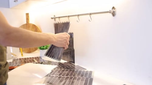 Man Applying Peel and Stick Tile in Kitchen