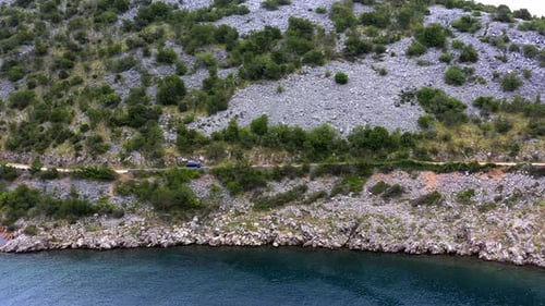 A campervan is driving slowly along the Croatian coast near Zadar.