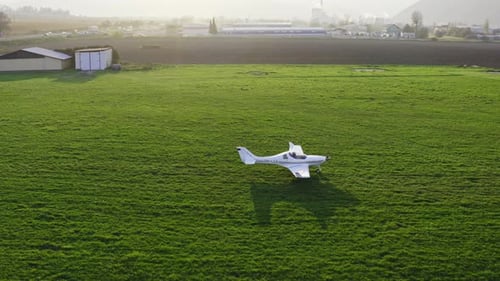 A Single-Engine White Plane Moving Through The Meadow In Slovakia. - Drone Tracking Shot