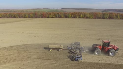 Big red combine working on the field cultivating and applying nitrogen ASP