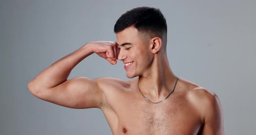 Face, flexing and man with wellness, bicep and workout with bodybuilder on gray studio background