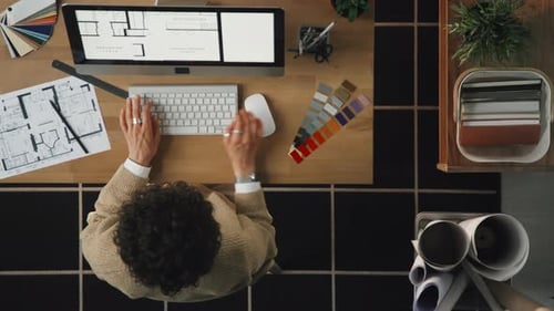 Architect Working with Blueprint on Computer