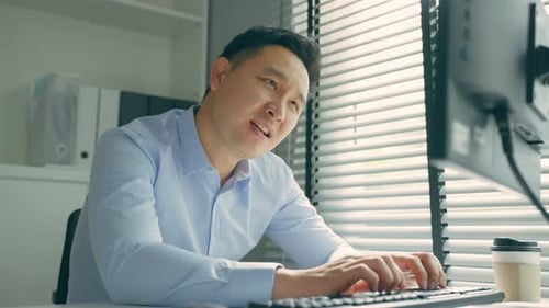 Exhausted Asain business man using laptop computer working in office.