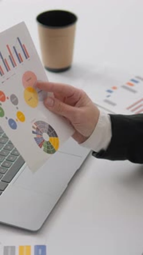 A Skilled Professional is Carefully Analyzing Financial Data Using Clear Graphs and Detailed Charts
