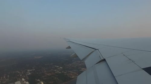 Airplane wing soaring above the city skyline a beautiful air transport journey