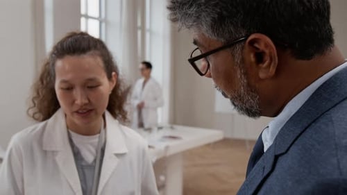 Medical Professionals Discussing a Chart in a Bright Office